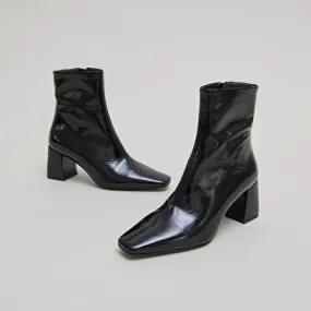 Pointed-toe ankle boots in black pleated patent