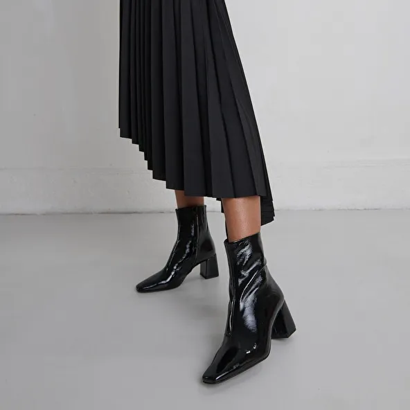 Pointed-toe ankle boots in black pleated patent