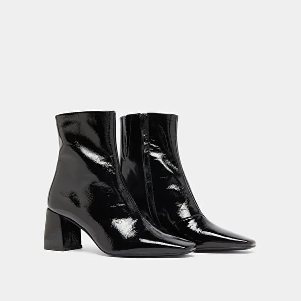 Pointed-toe ankle boots in black pleated patent