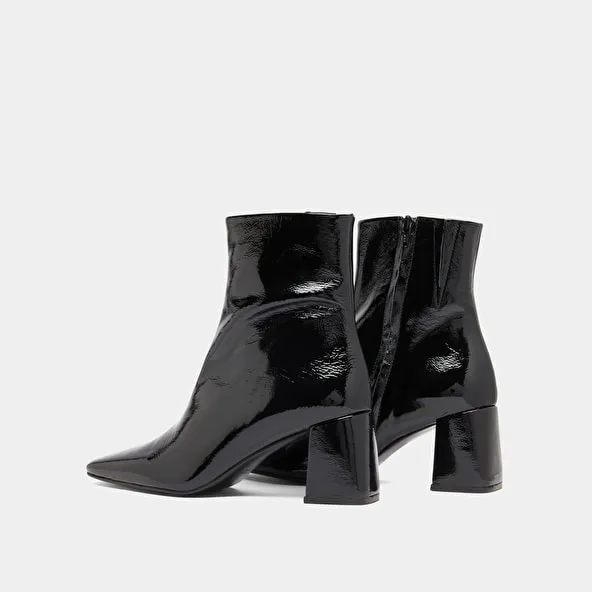 Pointed-toe ankle boots in black pleated patent