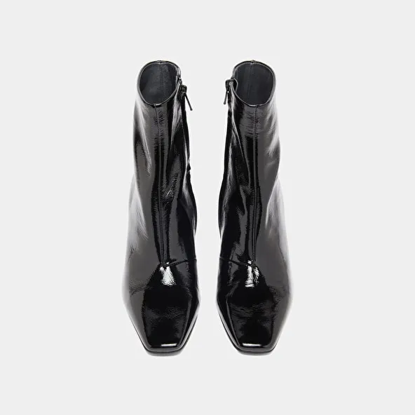 Pointed-toe ankle boots in black pleated patent